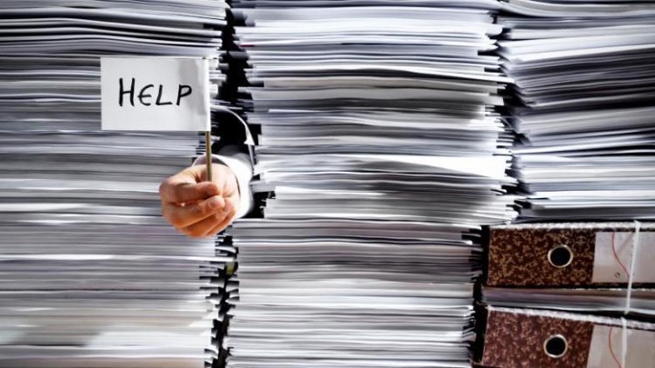 The major causes of workplace stress and poor wellbeing from the Welbee learning centre. Picture of piles of work to represent workload as one part of the Demands management standard.